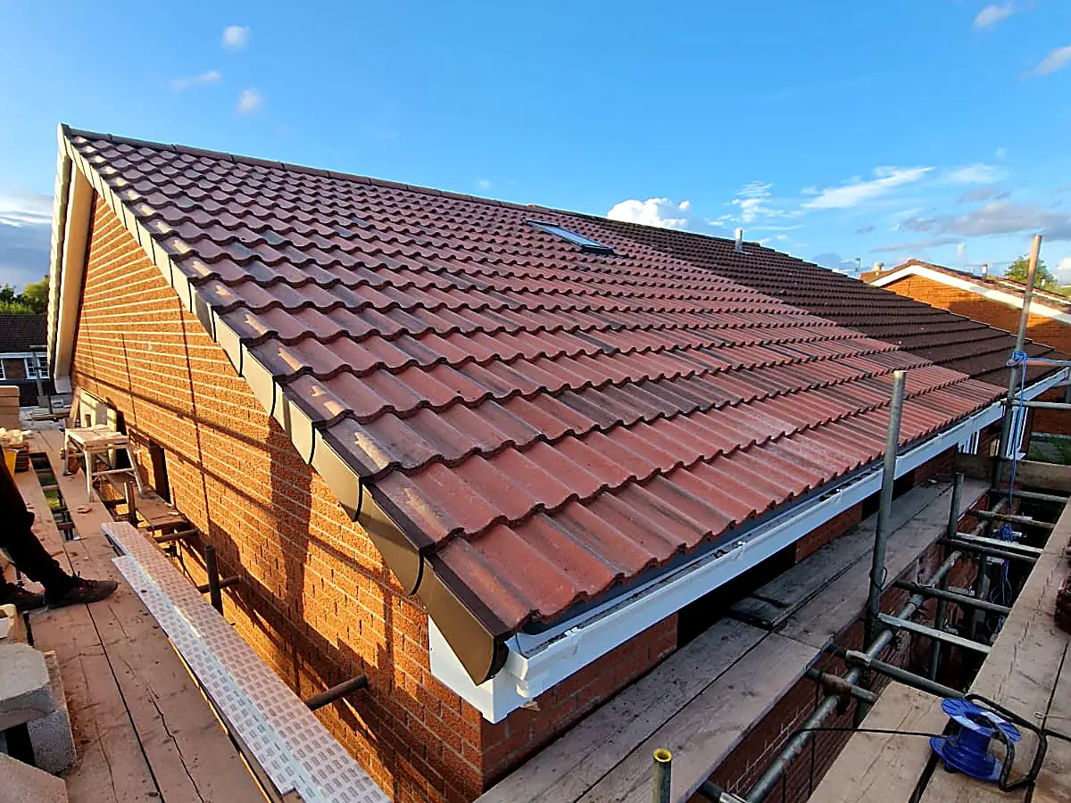 New guttering and white fascias fitted along a freshly tiled roof